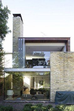 a brick building with a covered patio in the foreground and an outdoor living area on the other side