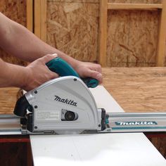 a man using a circular saw to cut plywood boards with a miter attachment