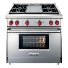 a silver stove with red knobs on it's burners and two oven doors