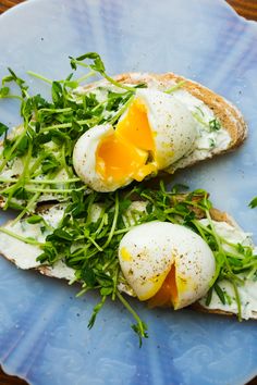 two pieces of bread topped with an egg and arugula