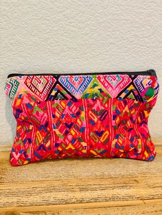 Beautiful Mayan cosmetic pouch with huipil textile. Hand woven by local artisans in Guatemala Featuring a 2-back zipper closure and a small charm/pompom. Each piece is handmade featuring a unique design. As a unique handmade product each product may vary. USES: Can be used as makeup bag, wallet, clutch to complement a casual outfit. Perfect for travel. As well to store purse necessities. MEASUREMENTS  Length: 9 inches Width: 7 inches  (approximately) MATERIAL & CARE Cotton We recommend hand wash separately with cold water. Do not bleach Hang to dry SHIPPING & RETURNS Handling time is 1 business day. Shipping can take 2-7 business days depending on your location. You will receive a tracking information once the package gets shipped. If you are not satisfied with your order, we accept return Bohemian Multicolor Clutch With Zipper Pouch, Handmade Pouch Clutch For Festivals, Bohemian Rectangular Clutch With Zipper Pouch, Bohemian Clutch With Zipper Pouch, Bohemian Woven Travel Pouch, Bohemian Rectangular Clutch With Zipper, Bohemian Clutch Pouch For Daily Use, Bohemian Handmade Travel Pouch, Bohemian Zipper Pouch