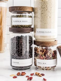 four glass jars filled with nuts and seeds