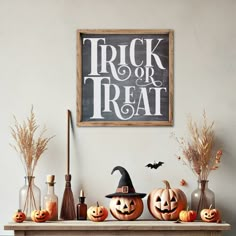 a mantle with pumpkins and witches on it, next to a trick or treat sign