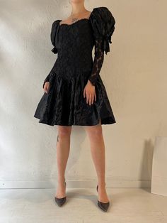 - Vintage black lace puff sleeve party dress - Lace sleeves and bodice - Zipper up the back - Sequins lining the bust  - Nylon acetate polyester - Made in USA - Tagged 9 Bust: 16.5" Waist: 14" Length: 35.5" We are not responsible for lost, stolen, or damaged packages once they have been shipped. Any additional customs duties or taxes incurred on international orders are the responsibility of the buyer. Please note that our items are vintage and may have minor flaws or imperfections due to their Evening Puff Sleeve Dress With Ruffles, Fitted Puff Sleeve Dress With Ruffles For Evening, Party Dress With Puff And Balloon Sleeves, Party Dress With Puff Balloon Sleeves And Fitted Bodice, Evening Dress With Puffy Sleeves, Fitted Puffy Evening Dresses, Evening Dresses With Puff Sleeves, Party Puff Sleeve Dress With Ruffles And Fitted Bodice, Evening Puff Sleeve Puffy Dress