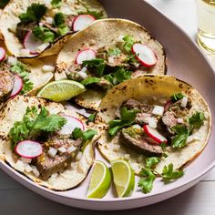 several tacos with meat, radishes and cilantro on a plate