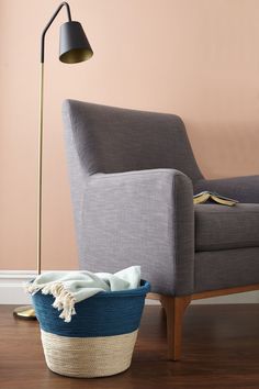 a living room with a chair, lamp and blanket on the floor next to it