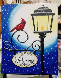 a welcome sign with a red bird on it and a street light in the background