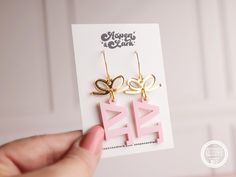 a pair of pink and gold earrings sitting on top of a card