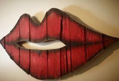 a red painted wooden lips on a white wall