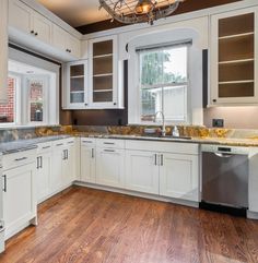 an empty kitchen with white cabinets and wood floors is pictured in this image from the inside