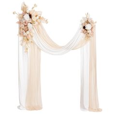 a wedding arch decorated with flowers and sheer drapes for the bride's ceremony