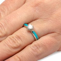 a woman's hand with a ring on it and a diamond in the middle