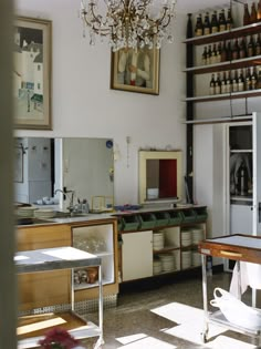 an old fashioned kitchen with lots of clutter on the counter and shelves above it