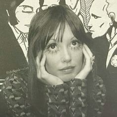 a black and white photo of a woman with her hands on her face in front of a painting