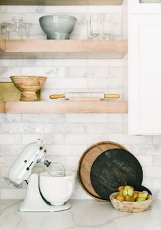 a kitchen counter with bowls and mixers on it