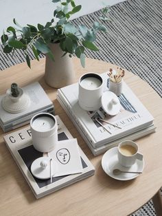 a table with two coffee cups and books on it