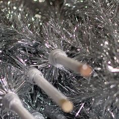 two white toothbrushes sitting on top of a silver tinseled christmas tree