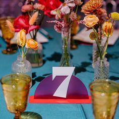 the table is set with vases and flowers