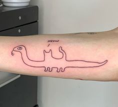 a person with a tattoo on their arm that has an image of a dinosaur drawn on it