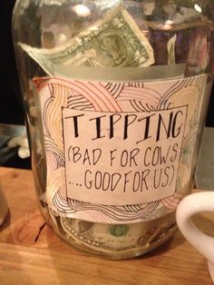 a jar filled with money sitting on top of a wooden table