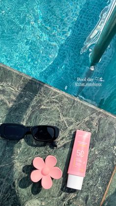 sunglasses and sunscreen next to a pool