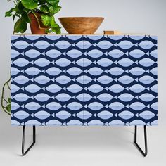 a blue cabinet sitting next to a potted plant on top of a wooden table