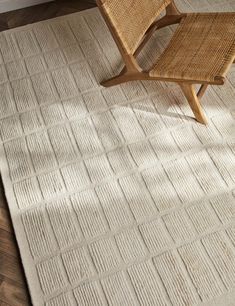 a chair sitting on top of a wooden floor next to a rug