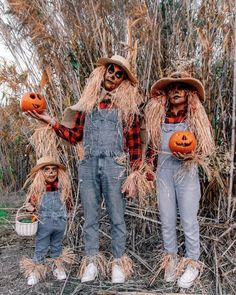 three scarecrows holding pumpkins in their hands while standing next to each other