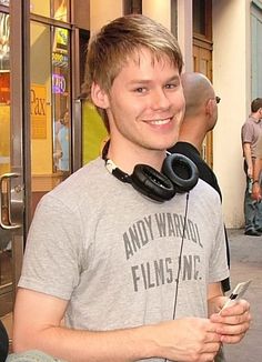 a young man wearing headphones on the street