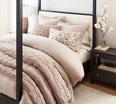 a bedroom with a canopy bed, pillows and blankets on top of the bedspread