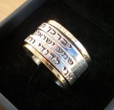 "Handmade Original Inscribed Hebrew 3 Spin Ring: 1) \"יברכך ה' וישמרך\" (\"The Lord Bless You & Keep You\") 2) שמע ישראל ה' אלוהינו ה' אחד (Hear O Lord is our God the LORD is One) 3) אני לדודי ודודי לי (I am My Beloved's and my beloved us mine). Description: ❇ Free worldwide shipping ❇ Material: 9k Solid Gold & Sterling Silver 925. ❇ Width (approx.): 2.0cm (0.79 inches) ❇ All Jewelry items are shipped inside a fancy gift box. ❇ All of my designs are HANDMADE. The inscription אני לדודי ודודי לי i Silver Engraved Ring Stamped 14k For Promise, Silver Promise Ring Stamped 14k, Spiritual Wedding Rings Engraved, Silver Stackable Wedding Rings Stamped 14k, Engraved Wide Band Rings As Gifts, Personalized Silver Rings For Marriage, Silver Anniversary Rings With Names, Adjustable Wedding Rings With Names, Personalized Silver Rings For Wedding