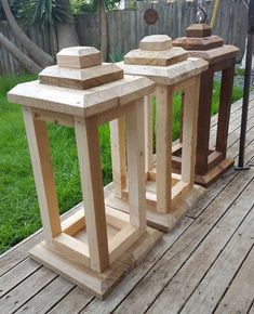 three wooden tables sitting on top of a wooden deck next to a fence and grass