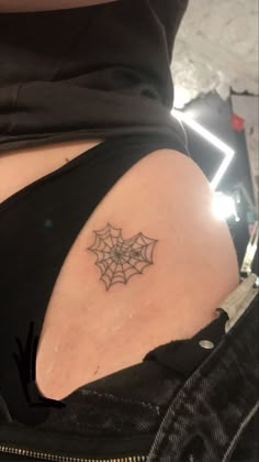 a woman with a spider web tattoo on her back