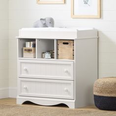 a baby changing table with two drawers and a stuffed animal on it's side