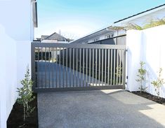 a white fence and gate in front of a house