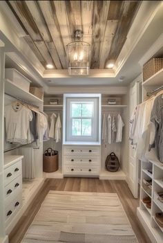 a walk in closet with white cabinets and drawers