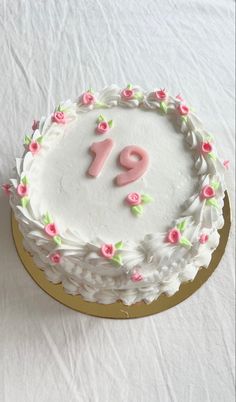 a white cake with pink frosting and flowers on the top that says 91th