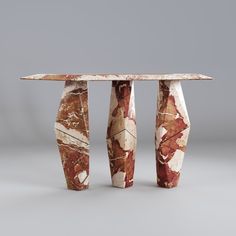 a table made out of marble sitting on top of a gray floor next to two vases