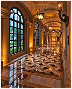 an image of a hallway with windows and marble flooring on the walls, along with chandeliers