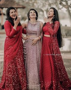 three women standing next to each other and laughing