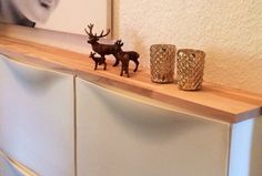 two deer figurines sitting on top of a wooden shelf