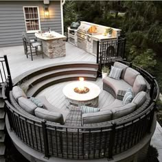 a fire pit sitting on top of a wooden deck next to a table and chairs