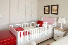 a baby's room with white and red furniture