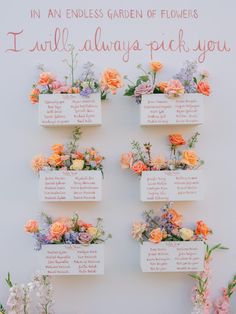 an arrangement of flowers is arranged on the wall for a wedding seating card holder display