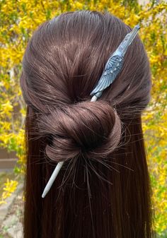 A Silver and blue hair stick with sparkly crystal angel wing with blue luster polished crystal measuring 6.5 inches long. A hand painted polymer clay hair art piece with a pale blue luster polished point crystal. The wooden core of this hair pin is hand painted silver. This beautiful bun pin will add the finishing touch to decorate your hair bun or up-do. Features of this hair bun accessory 6.5 inches Wooden Polymer clay Blue polished luster crystal Hand painted Decorative blue angel wing with c Silver And Blue Hair, Angel Wings Hair, Polymer Clay Hair, Painted Polymer Clay, Clay Hair, Ethereal Elegance, Bun Pins, Fantasy Necklace, Beautiful Buns