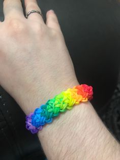 a person wearing a rainbow colored bracelet on their wrist and hand with the colors of the rainbow