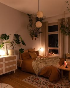 a bed room with a neatly made bed and plants on the windows sill next to it