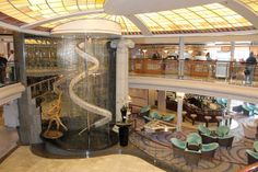 the inside of a large cruise ship with many chairs and tables on each side of it