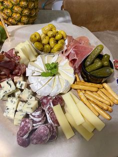 an assortment of cheeses and meats on a platter