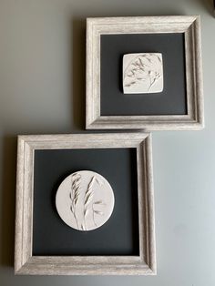 two framed artwork pieces are on the wall next to each other, one is white and black